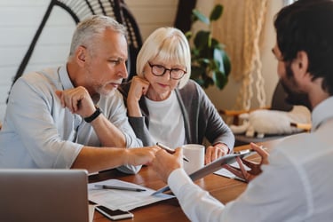 elderly couple signing insurance paperwork